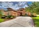 Two-story house with terracotta tile roof, landscaped yard, and a three-car garage at 20103 Shady Hill Ln, Tampa, FL 33647