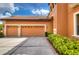 Two-car garage with light beige doors and neatly trimmed landscaping at 20103 Shady Hill Ln, Tampa, FL 33647