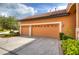 Two-car garage with light beige doors and neatly trimmed landscaping at 20103 Shady Hill Ln, Tampa, FL 33647