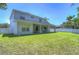 Spacious backyard featuring green lawn, covered patio, and white vinyl fencing at 5103 Ashcrest Ct, Tampa, FL 33647