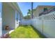 A well-maintained, fenced backyard featuring lush green grass and a white fence at 5103 Ashcrest Ct, Tampa, FL 33647