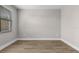 Minimalist bedroom with wood-look flooring, neutral walls, and a window with blinds at 5479 Brussels Ter, Port Charlotte, FL 33981