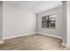 Bright, airy bedroom featuring a large window, neutral walls, and wood-look flooring at 5479 Brussels Ter, Port Charlotte, FL 33981