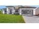 Charming single-story home featuring a well-manicured lawn and a gray two-car garage at 5479 Brussels Ter, Port Charlotte, FL 33981