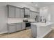 Modern kitchen featuring gray cabinets, stainless appliances, and a bright white countertop island at 5479 Brussels Ter, Port Charlotte, FL 33981