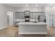 Open concept kitchen featuring stainless steel appliances, gray cabinets, and a large island at 5479 Brussels Ter, Port Charlotte, FL 33981