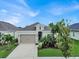 House front with palm trees and landscaping at 7112 Estero Ct, Apollo Beach, FL 33572