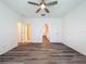 Bedroom with wood-look floors, ceiling fan, and access to bathroom and hallway at 9224 Fox Sparrow Rd, Tampa, FL 33626