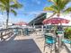 Relaxing waterfront patio seating area with red and white umbrellas at 4354 50Th S Ter, St Petersburg, FL 33711