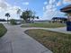 Concrete pathway winds through grassy park area toward waterfront at 469 80Th Way, St Pete Beach, FL 33706