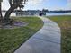 Curving concrete path leads to waterfront with views of homes and bridge at 469 80Th Way, St Pete Beach, FL 33706