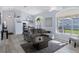 Bright living room with vaulted ceiling, L-shaped sofa, and large windows at 11036 Via De Rosa Ln, Spring Hill, FL 34608