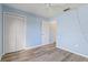 Light blue bedroom with wood-look flooring and double door closet at 3832 Lanyard Ct, New Port Richey, FL 34652