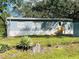 Blue mobile home with a wooden deck and landscaped yard at 10642 Shalimar St, New Port Richey, FL 34654
