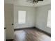 Simple bedroom with wood-look floors and ceiling fan at 10642 Shalimar St, New Port Richey, FL 34654