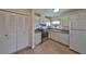 Bright kitchen with white appliances and cabinetry, featuring a spacious pantry and durable laminate flooring at 1529 Allegheny Dr, Sun City Center, FL 33573