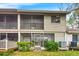 Tan two-story home with screened porch, deck, and landscaping at 1924 Whispering Way, Tarpon Springs, FL 34689