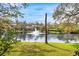 Serene pond view with fountain and lush green landscaping at 1924 Whispering Way, Tarpon Springs, FL 34689