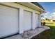Three-car garage with white roll-up doors at 332 Club Manor Dr # 10, Sun City Center, FL 33573