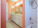 Double sink bathroom with coral walls and tile at 332 Club Manor Dr # 10, Sun City Center, FL 33573