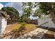 View of the backyard featuring mature trees, fencing for privacy, and a storage shed at 8950 3Rd N St, St Petersburg, FL 33702