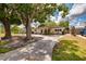 Well-maintained single-story home featuring a concrete driveway and mature trees at 8950 3Rd N St, St Petersburg, FL 33702