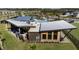 Aerial view of a modern community clubhouse with metal roof and outdoor seating at 31081 Pendleton Landing Cir, Wesley Chapel, FL 33545