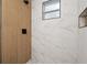 Modern shower with marble-look tile, wood-look paneling, and black fixtures at 1021 E 25Th Ave, Tampa, FL 33605