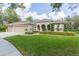 Three-car garage, manicured lawn, and impressive facade at 15802 Sorawater Dr, Lithia, FL 33547