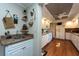 White kitchen cabinets, wood floors, and a breakfast bar with a small sink at 3006 Bolt Dr, Palm Harbor, FL 34685