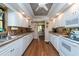White kitchen with wood floors, stainless steel appliances, and lots of cabinet space at 3006 Bolt Dr, Palm Harbor, FL 34685