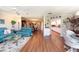 Bright living room with teal couches, wood floors, and views into dining area and kitchen at 3006 Bolt Dr, Palm Harbor, FL 34685