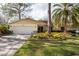 House exterior featuring a two-car garage and well-manicured landscaping at 3006 Bolt Dr, Palm Harbor, FL 34685
