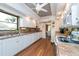 White kitchen with wood floors, lots of counter space and a view into the dining area at 3006 Bolt Dr, Palm Harbor, FL 34685