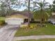 Attractive home exterior with a two-car garage and landscaped yard at 3006 Bolt Dr, Palm Harbor, FL 34685