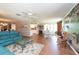 Open living area with hardwood floors, a large mural, and comfortable seating at 3006 Bolt Dr, Palm Harbor, FL 34685