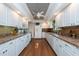 Long kitchen with white cabinets, wood floors, and ample counter space at 3006 Bolt Dr, Palm Harbor, FL 34685