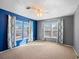 Stylish bedroom with contrasting blue and gray walls, ceiling fan, and bright windows for ample light at 500 53Rd S St, St Petersburg, FL 33707