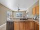 Kitchen with light wood cabinets, stainless steel dishwasher and double sink at 500 53Rd S St, St Petersburg, FL 33707