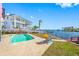 Private pool with blue water, a chair, and canal and neighbor's house views at 5410 Pali Way, St Pete Beach, FL 33706