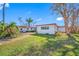Backyard view of single-story home with grassy area at 5412 Pali Way, St Pete Beach, FL 33706