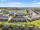 Aerial view showcases the community's well-maintained townhomes, picturesque landscaping, and serene lake at 8607 Canyon Creek Trl, Parrish, FL 34219