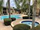 Community pool and spa with brick pavers and lush landscaping at 10196 Sailwinds S Blvd # 107, Largo, FL 33773