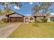 Ranch style home with a brown garage door and arched entryway at 140 Meadowlark Dr, Safety Harbor, FL 34695