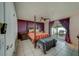 Main bedroom with a post bed, orange bedding, and access to the backyard at 140 Meadowlark Dr, Safety Harbor, FL 34695
