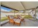 Relaxing screened porch with wicker chairs and ottoman at 140 Meadowlark Dr, Safety Harbor, FL 34695
