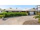 Contemporary home with gray facade, white garage door, and lush greenery at 2599 W Bay Isle Se Dr, St Petersburg, FL 33705
