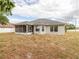 House back view with screened porch and yard at 3027 Aldoro Ave, Spring Hill, FL 34609