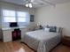 Well-lit bedroom featuring a ceiling fan, white desk, and stylish silver bedding at 6060 Shore S Blvd # 705, Gulfport, FL 33707