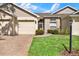 Beige exterior with a two-car garage and landscaping at 2403 Nantucket Green Ct # 0, Sun City Center, FL 33573